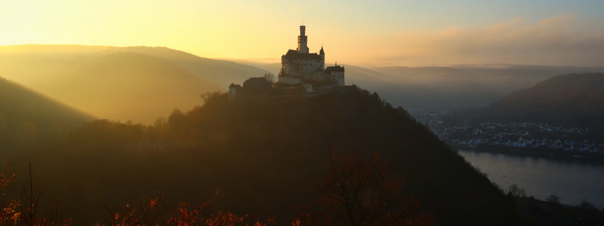 Marksburg Sonnenuntergang ©  Die Marksburg auf einer Höhe mit Rhein und benebelten Bergen beim Sonnenuntergang ©