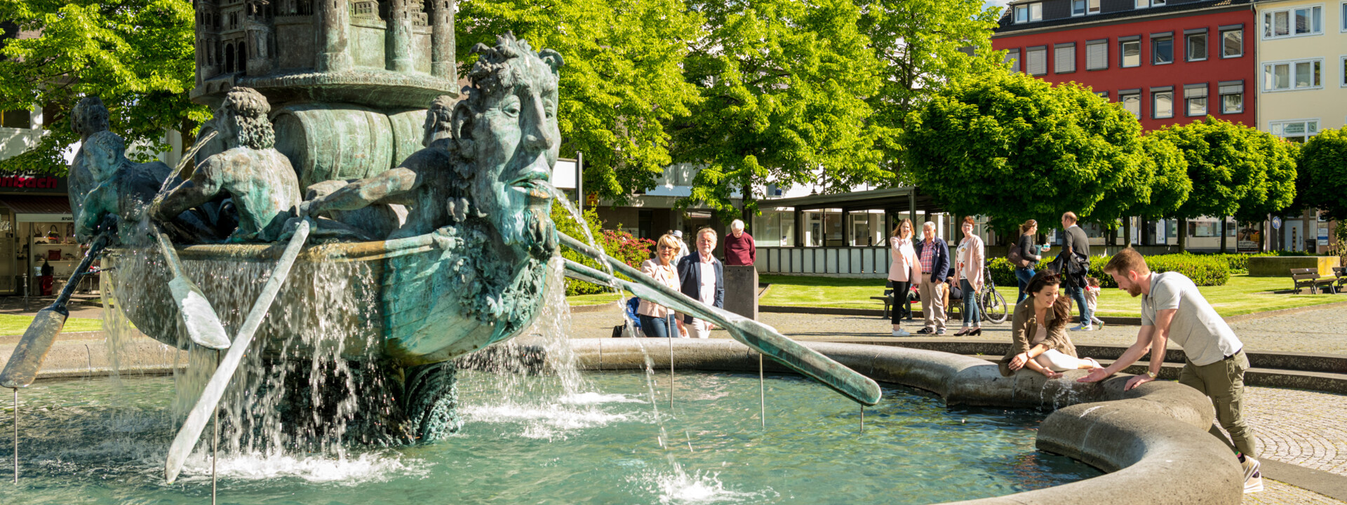 Brunnen "Historiensäule" auf dem Görresplatz in Koblenz umgeben von kleinen Menschengruppen © Koblenz-Touristik GmbH, Dominik Ketz Brunnen "Historiensäule" auf dem Görresplatz in Koblenz umgeben von kleinen Menschengruppen © Koblenz-Touristik GmbH, Dominik Ketz