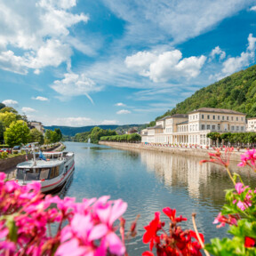 Bad Ems Lahn pinke Blumen ©  Pinke Blumen bluten vor der Lahn mit romantischen Gebäuden und einem kleinen Schiff im Hintergrund ©