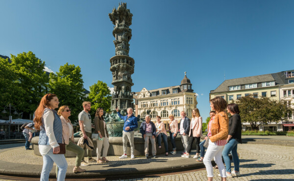 Koblenz-Touristik-2019-286.jpg © Koblenz-Touristik GmbH, Dominik Ketz Touristen stehen auf dem Görresplatz und schauen sich die Historiensäule an. © Koblenz-Touristik GmbH, Dominik Ketz