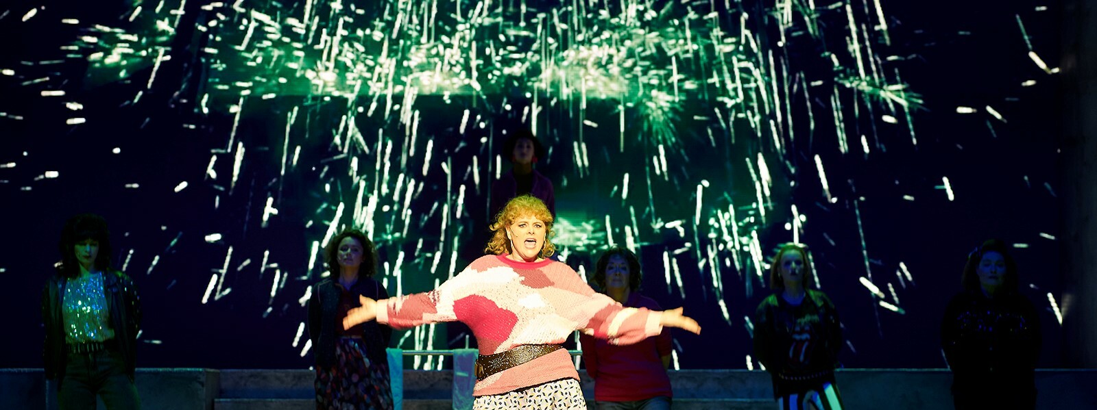 © Theater Koblenz Darstellerin mit offenen Armen steht auf der Buhne vor Funken © Theater Koblenz