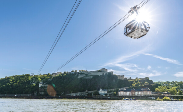 Kampage_2021_Bildmotive-einzeln_1920x1080px_05.2021_01q.jpg © Koblenz-Touristik GmbH, Dominik Ketz Die Seilbahn Koblenz im Gegenlicht der Sonne mit Rhein im Vordergrund und Festung Ehrenbreitstein im Hintergrund © Koblenz-Touristik GmbH, Dominik Ketz