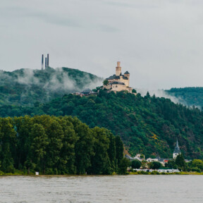© Koblenz-Touristik GmbH, Henry Tornow Blick auf die Marksburg vom Rheinufer umgeben von Bergen und Wald mit dem Rhein im Vordergrund © Koblenz-Touristik GmbH, Henry Tornow