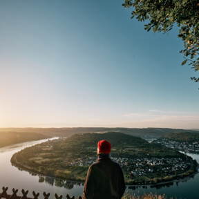 © Philip Bruederle Mann blickt auf die Rheinschleife beim Sonnenaufgang © Philip Bruederle
