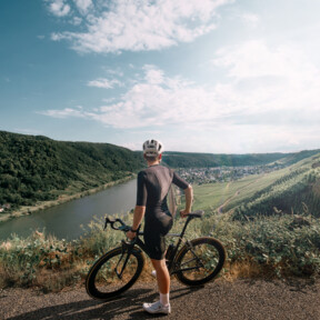 Radfahrer an der Mosel © Koblenz-Touristik GmbH, Philip Bruederle Man sieht einen Mountainbike-Fahrer von hinten, der in die Ferne auf die Mosel und die Weinberge blickt © Koblenz-Touristik GmbH, Philip Bruederle