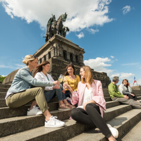 Mädels Wein Deutsches Eck © Koblenz-Touristik GmbH, Dominik Ketz Mädels trinken Wein auf den Stufen des Deutschen Ecks © Koblenz-Touristik GmbH, Dominik Ketz