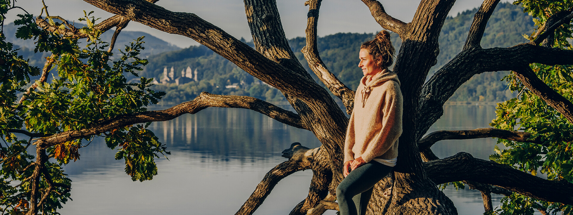 Dame von Seite blickt auf den Sonnenaufgang bei Maria Laach mit dem Kloster und See im Hintergrund © Koblenz-Touristik GmbH, Philip Bruederle Dame von Seite blickt auf den Sonnenaufgang bei Maria Laach mit dem Kloster und See im Hintergrund © Koblenz-Touristik GmbH, Philip Bruederle