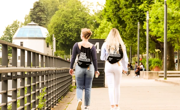 Zwei Mädels sitzen auf einer Mauer mit einer Flasche Wein und schauen ihre WeinStadtWander-Route auf einer Karte an. © Koblenz-Touristik, Johannes Bruchhof Zwei Mädels sitzen auf einer Mauer mit einer Flasche Wein und schauen ihre WeinStadtWander-Route auf einer Karte an. © Koblenz-Touristik, Johannes Bruchhof
