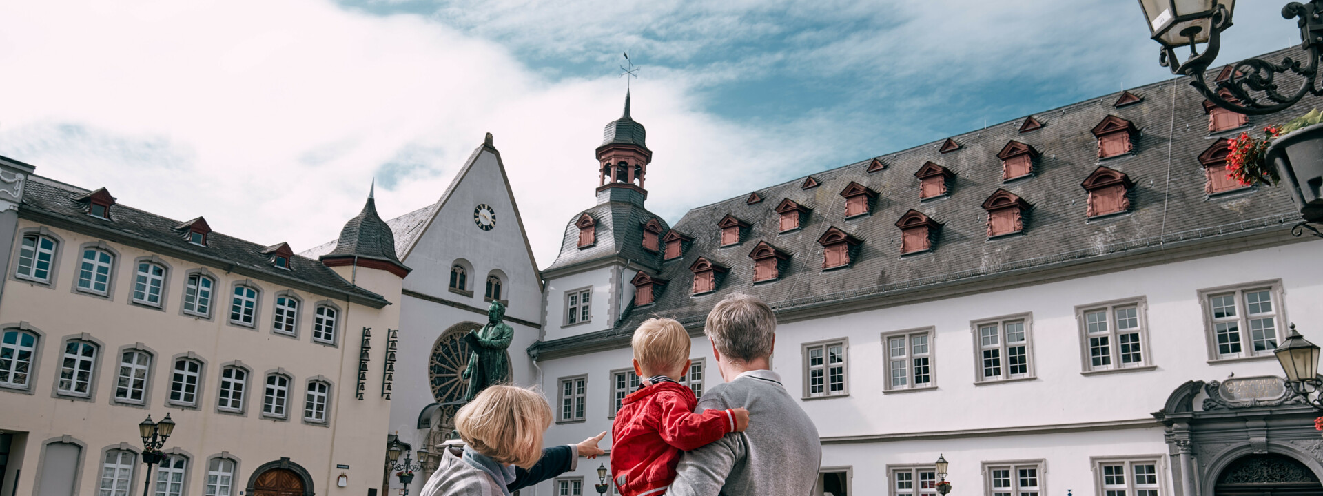 Großeltern mit Enkeln am Rathaus © Koblenz-Touristik GmbH, Philip Bruederle Rentner mit 2 Enkelkindern zeigen den Jesuitenplatz in Koblenz © Koblenz-Touristik GmbH, Philip Bruederle