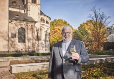 Lächelnder Stadtführer mit einem Glas Wein in der Hand steht vor dem Basilika St. Kastor im Herbst © Koblenz-Touristik GmbH, Picture Colada Lächelnder Stadtführer mit einem Glas Wein in der Hand steht vor dem Basilika St. Kastor im Herbst © Koblenz-Touristik GmbH, Picture Colada