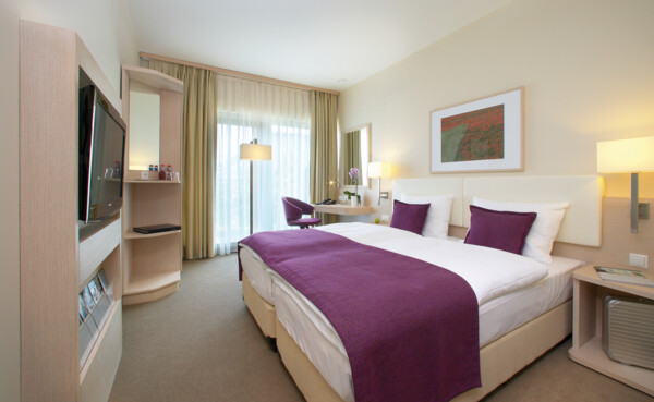 Hotelzimmer mit Teppichboden, Bodenfenster und Fernseher ©  Hotelzimmer mit Teppichboden, Bodenfenster und Fernseher ©