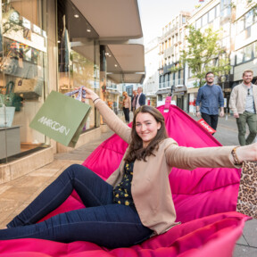 © Koblenz-Touristik GmbH, Dominik Ketz Frau mit Einkaufstüten sitzt auf Fatboy-Stuhl und streckt die Arme aus © Koblenz-Touristik GmbH, Dominik Ketz
