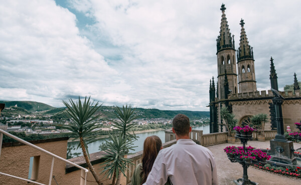 Pärchen von Hinten im Paradiesgarten blickt auf die Türme des Schloss Stolzenfels © Koblenz-Touristik GmbH, Philip Bruederle