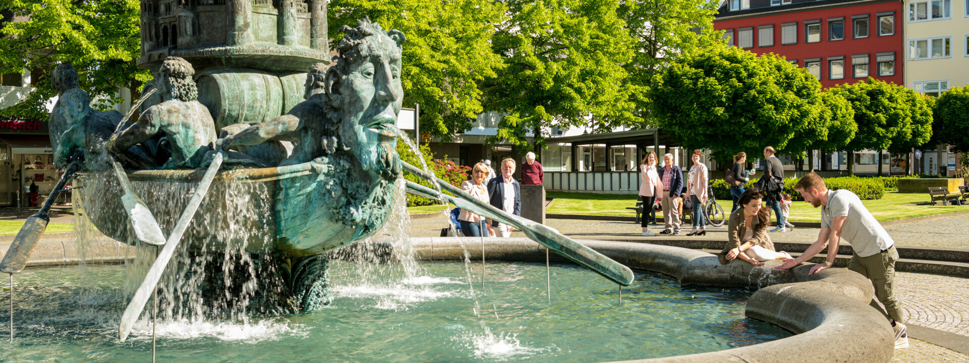 Brunnen Historiensäule Görresplatz Koblenz © Koblenz-Touristik GmbH, Dominik Ketz Brunnen "Historiensäule" auf dem Görresplatz in Koblenz umgeben von kleinen Menschengruppen © Koblenz-Touristik GmbH, Dominik Ketz
