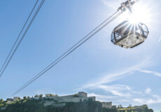 Kampage_2021_Bildmotive-einzeln_1920x1080px_05.2021_01q.jpg © Koblenz-Touristik GmbH, Dominik Ketz Die Seilbahn Koblenz im Gegenlicht der Sonne mit Rhein im Vordergrund und Festung Ehrenbreitstein im Hintergrund © Koblenz-Touristik GmbH, Dominik Ketz