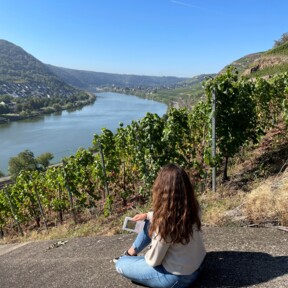 Frau sitzt in den Weinbergen bei Koblenz-Güls auf Stein und liest Buch © Koblenz-Touristik