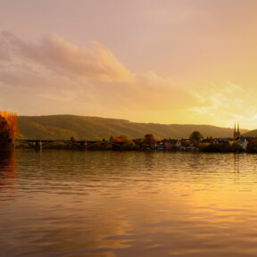 Mosel bei Sonnenuntergang © Johannes Bruchhof Blick über die Mosel bei Sonnenuntergang, im Hintergrund ein kleiner Ort mit Kirchturmspitze © Johannes Bruchhof