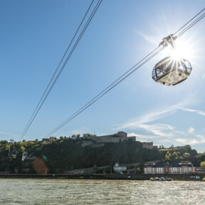 © Koblenz-Touristik GmbH, Dominik Ketz Die Seilbahn Koblenz im Gegenlicht der Sonne mit Rhein im Vordergrund und Festung Ehrenbreitstein im Hintergrund © Koblenz-Touristik GmbH, Dominik Ketz