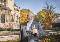 © Koblenz-Touristik GmbH, Picture Colada Lächelnder Stadtführer Michael Hörter mit einem Glas Wein in der Hand steht vor dem Basilika St. Kastor im Herbst © Koblenz-Touristik GmbH, Picture Colada