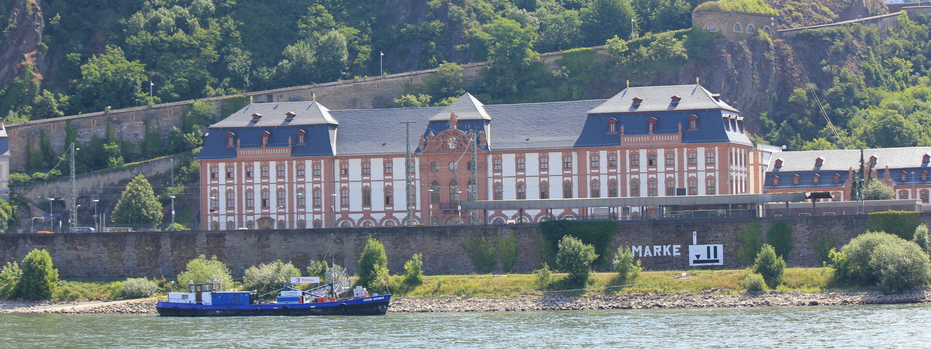 Dikasterialgebäude am Rheinufer vor der Festung Ehrenbreitstein mit dem Rhein im Vordergrund © Koblenz-Touristik GmbH Dikasterialgebäude am Rheinufer vor der Festung Ehrenbreitstein mit dem Rhein im Vordergrund © Koblenz-Touristik GmbH
