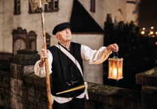 © Koblenz-Touristik GmbH, Picture Colada Stadtführer, bekleidet als früherer Nachtwächter, hält Laterne und Hellebarde vor der Alten Burg in Koblenz © Koblenz-Touristik GmbH, Picture Colada