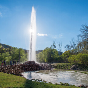 © Geysir.info GmbH, Klaus-Peter Kappes Geysir Andernach hinterbeleuchtet von der Sonne mit beobachtenden Menschen im Vordergrund © Geysir.info GmbH, Klaus-Peter Kappes