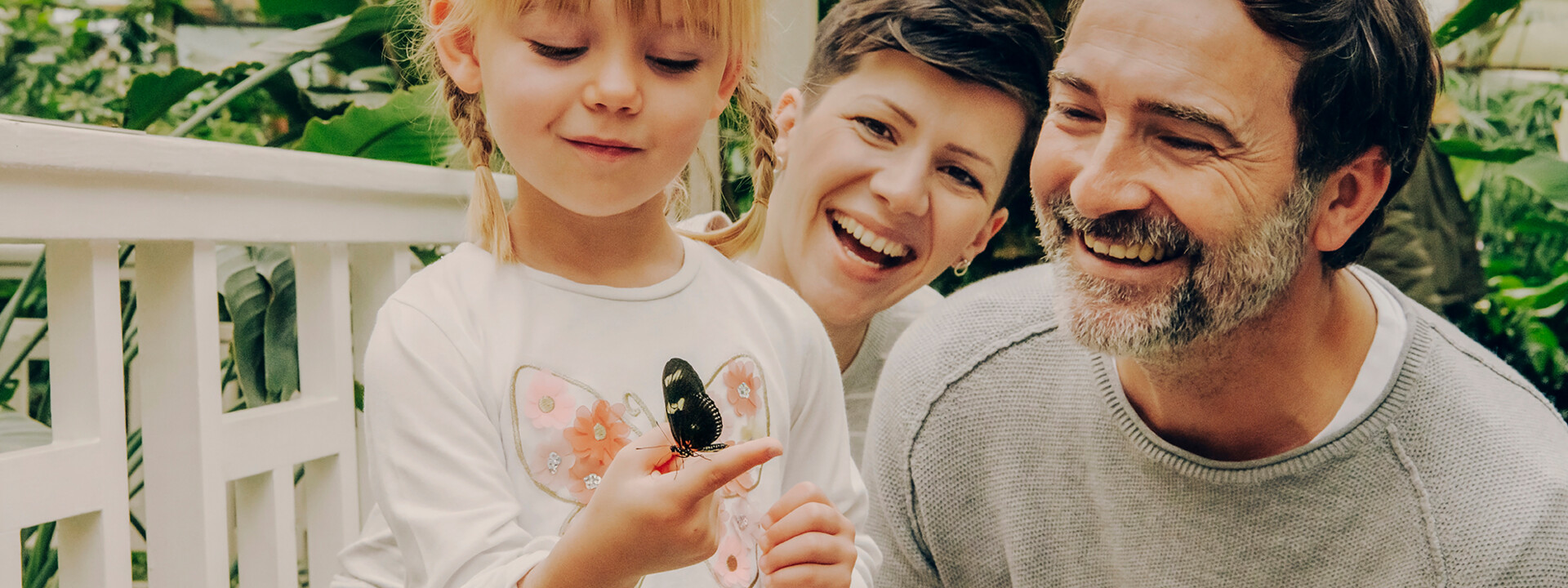 Familie im Schmetterlingsgarten in Sayn lachen während Tochter einen Schmetterling auf ihrem Finger beobachtet © Koblenz-Touristik GmbH, Philip Bruederle Familie im Schmetterlingsgarten in Sayn lachen während Tochter einen Schmetterling auf ihrem Finger beobachtet © Koblenz-Touristik GmbH, Philip Bruederle