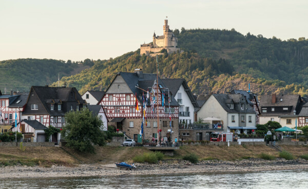Marksburg  © Dominik Ketz Blick auf die Marksburg, umgeben von Wald, im Vordergrund der Rhein und Fachwerkhäuser © Dominik Ketz