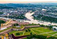 Luftaufnahme über der Festung Ehrenbreitstein mit der Stadt Koblenz und dem Zusammenfluss von Rhein und Mosel im Hintergrund. © 