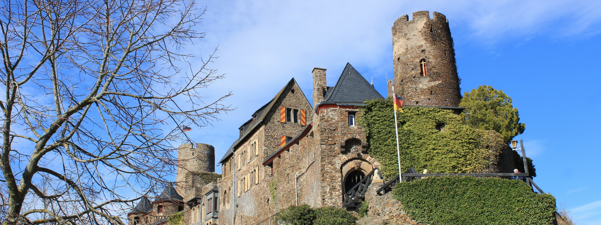 Burg Thurant © Koblenz-Touristik GmbH, Katharina Röper  Blick auf die Burg Thurant auf einer Bergkuppe, im Vordergrund ein Baum ohne Blätter und im Hintergrund blauer Himmel © Koblenz-Touristik GmbH, Katharina Röper
