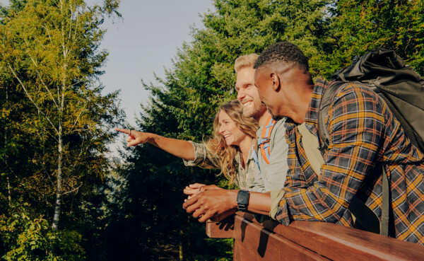 Wandergruppe Wald Koblenz © Koblenz-Touristik GmbH, Philip Bruederle Freundesgruppe steht am Zaun und lacht während eine auf etwas in der Entfernung zeigt © Koblenz-Touristik GmbH, Philip Bruederle