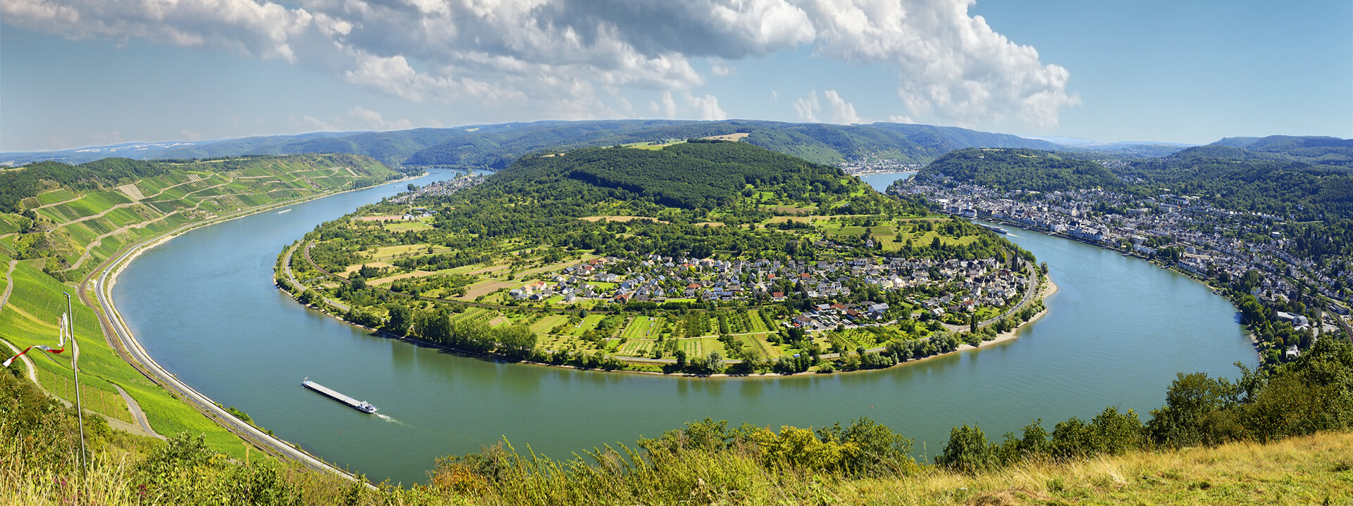 ©  Rheinschleife über Boppard bei sonnigem Himmel mit Schiff auf dem Fluss und Weinbergen im Hintergrund ©