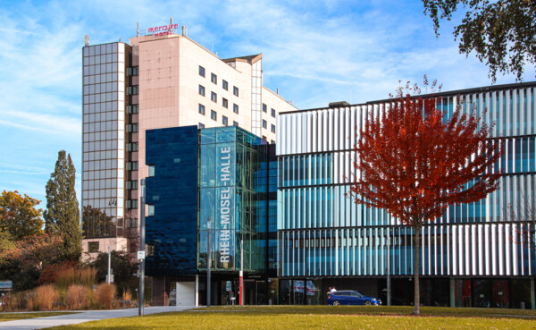 Rhein-Mosel-halle von der Vorderseite mit rotem Baum auf dem Rasen © Johannes Bruchhof Rhein-Mosel-halle von der Vorderseite mit rotem Baum auf dem Rasen © Johannes Bruchhof