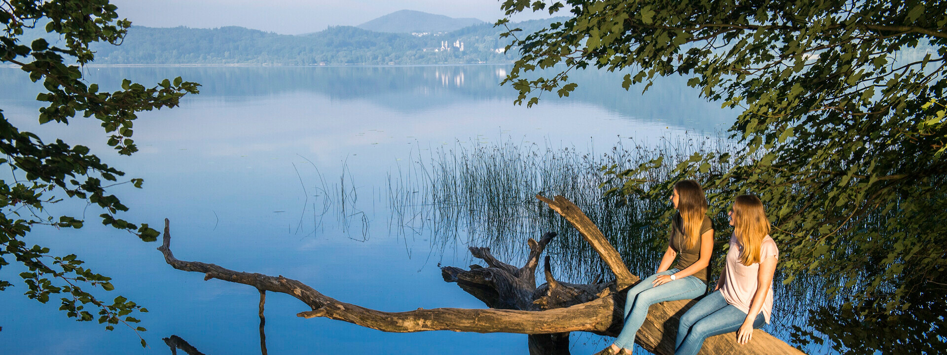 Kampage_2021_Bildmotive-einzeln_1920x1080px_05.2021_01p.jpg ©  Freundinnen sitzen auf einem Baumstamm bei Maria Laach ©